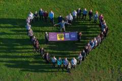 Aerial photograph of a group of business people stood in a heart shape